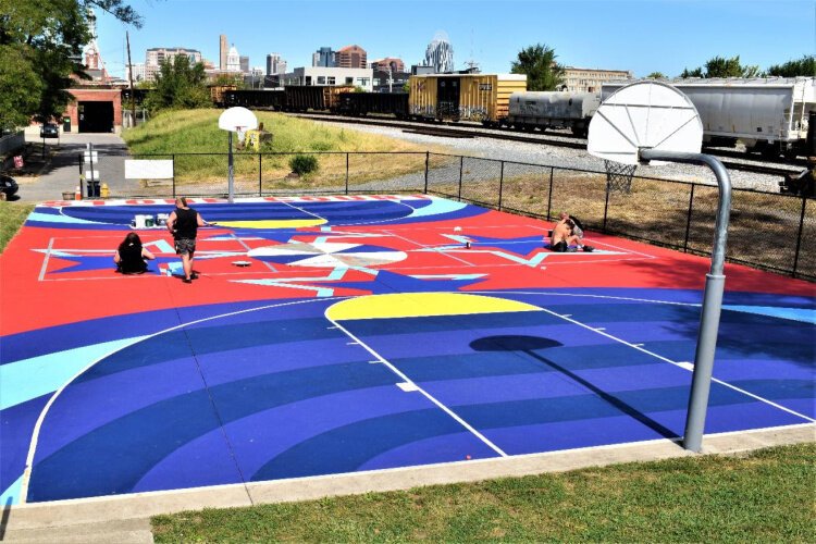 From left, Sam Becker, Thad Becker, Alexander Giehl, and Jarrod Becker - all of Covington design firm BLDG Refuge - paint the mural on George Stone Court.