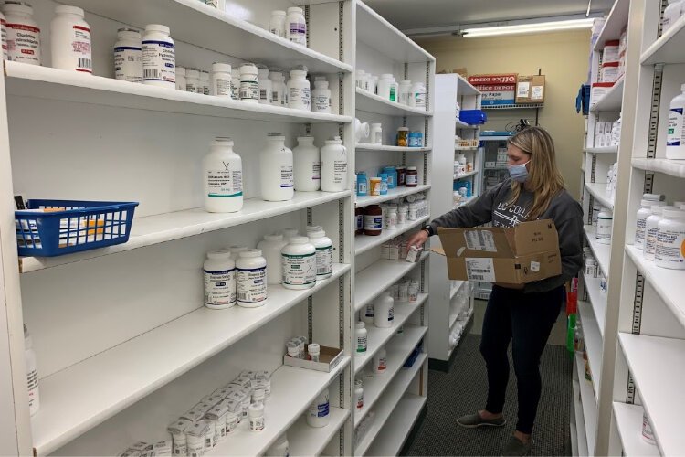 Stocking shelves is Meagen Rawers, an intern from UC. Interns rotate monthly at Faith Pharmacy.