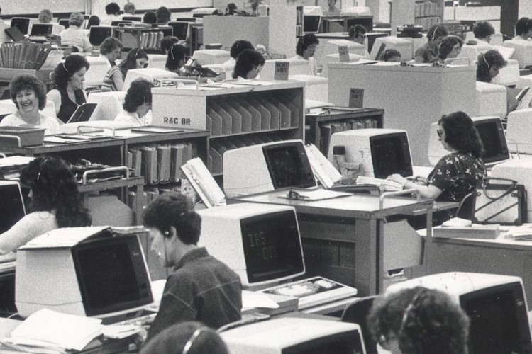 A vintage photo from the center's interior of workers processing tax returns.