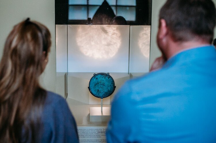 Museum guests contemplating the image behind the art.