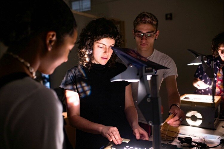 Lizzy DuQuette, ArtWorks teaching artist, demonstrates shadow puppetry to her youth apprentice team. DuQuette worked with four apprentices to create a shadow puppet play to be performed at BLINK. 